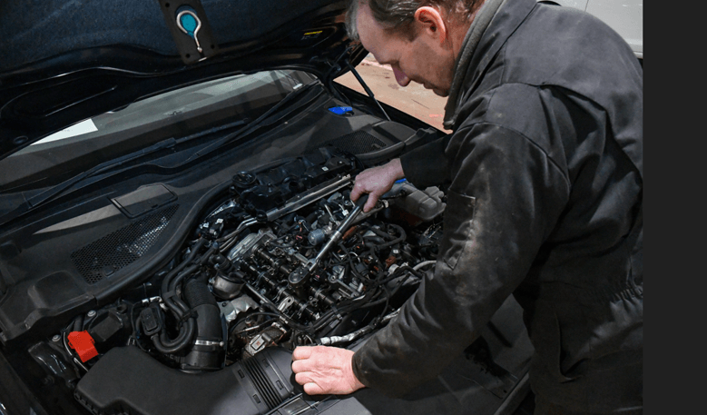 A mechanic working on an Air Con System in a car